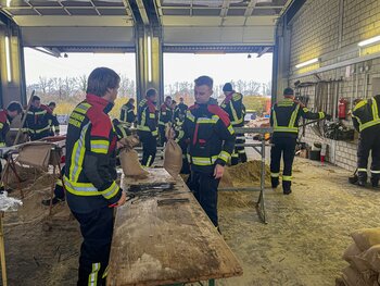 Einsatzkräfte befüllen Sandsäcke