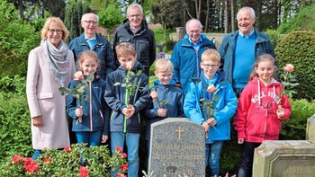 An den 100. Todestag erinnerten Schüler der Joseph-Tiesmeyer-Grundschule mit Rektorin Hannelen Hartke und legten gemeinsam mit (hinten von links) Franz Schräer, Hermann-Josef Niehof, Alexander Herbermann und Hermann Hasken am Grab Blumen nieder. Foto: Heinz Krüssel